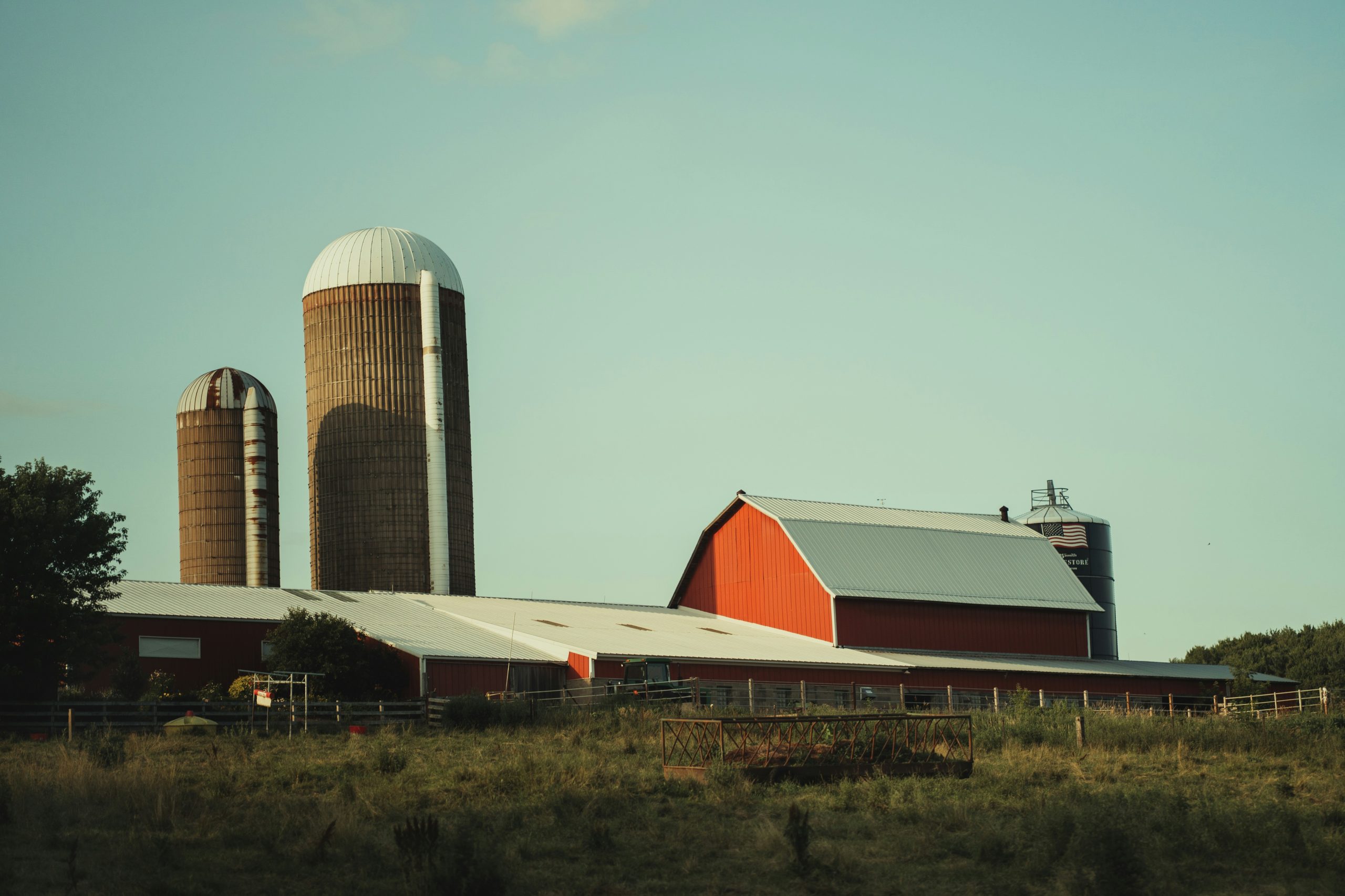 A red and white Wisconsin barn framed by green trees on a summer day.