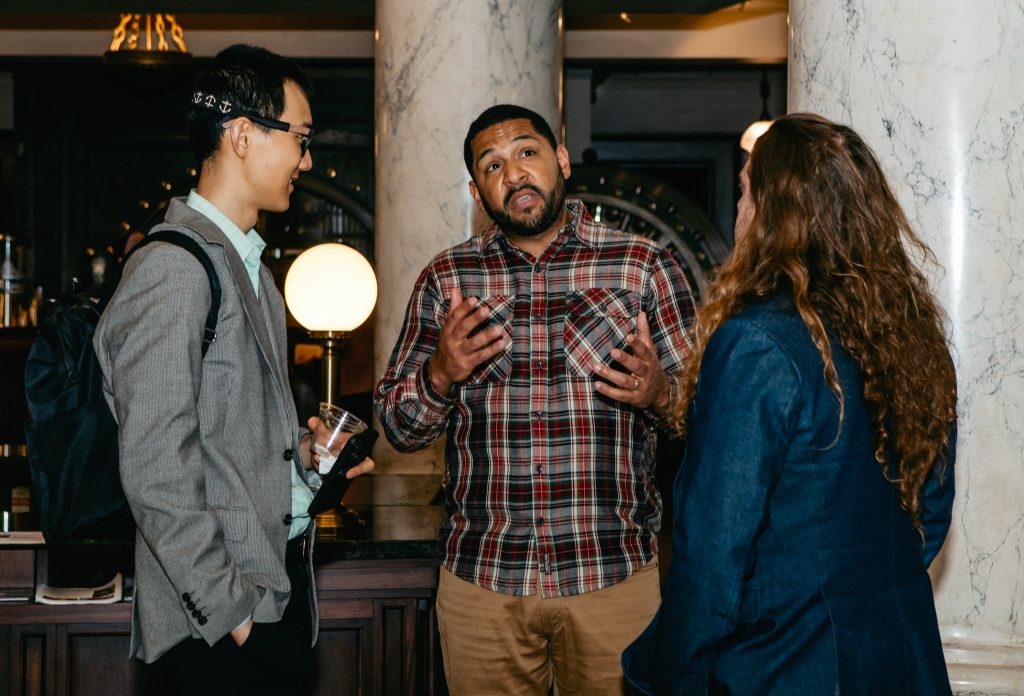 Three attendees in conversation during the networking reception.