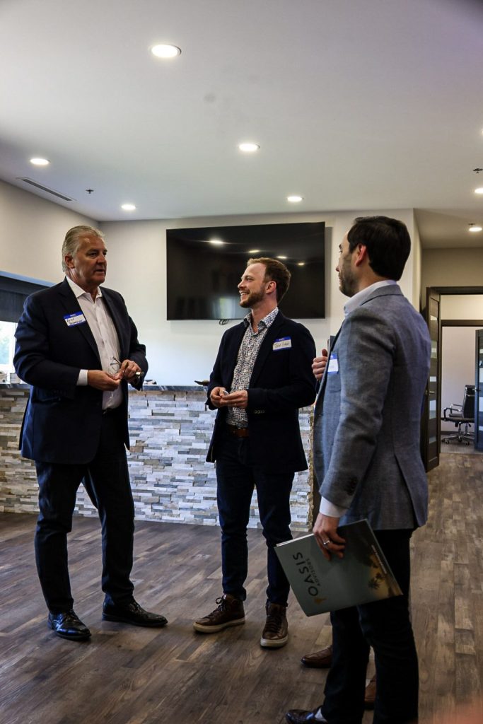 Three attendees in conversation in the lobby before the program.