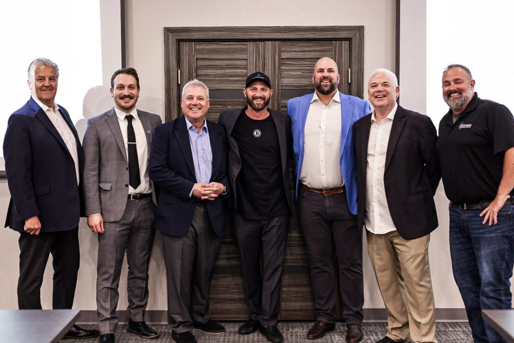 A group photograph of speakers and organizers standing together at the close of the forum.
