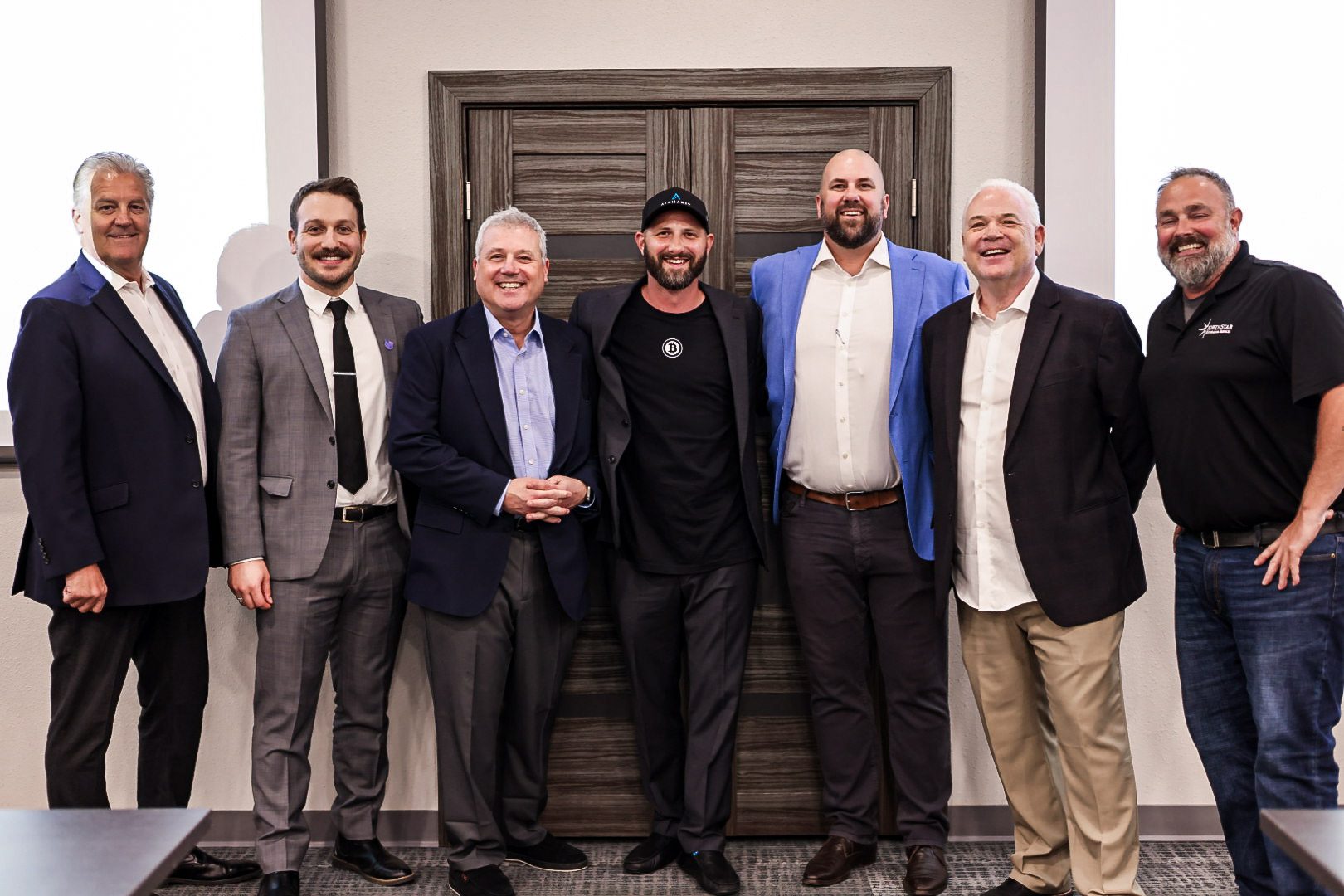 A group photograph of speakers and organizers standing together at the close of the forum.